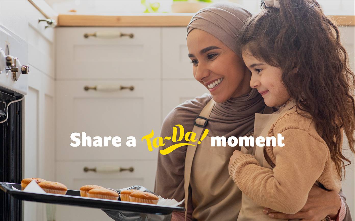 A woman baking with her daughter with the headline"Share a Ta-Da! moment". Designed by Mighty, brand agency