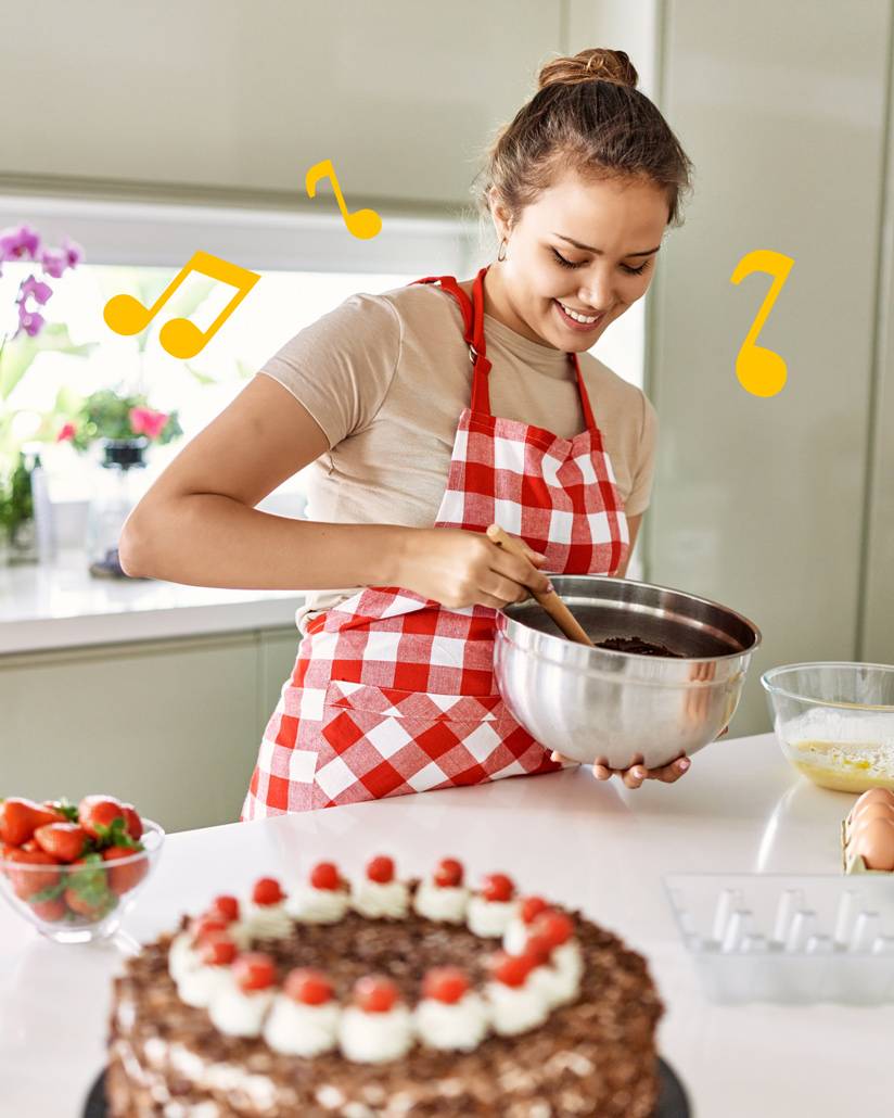 A woman baking surrounded by the musical notes that inspired the Ta-Da logo. Designed by Mighty, brand agency