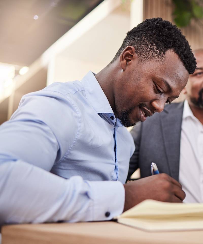 Young office worker writing things down in a meeting
